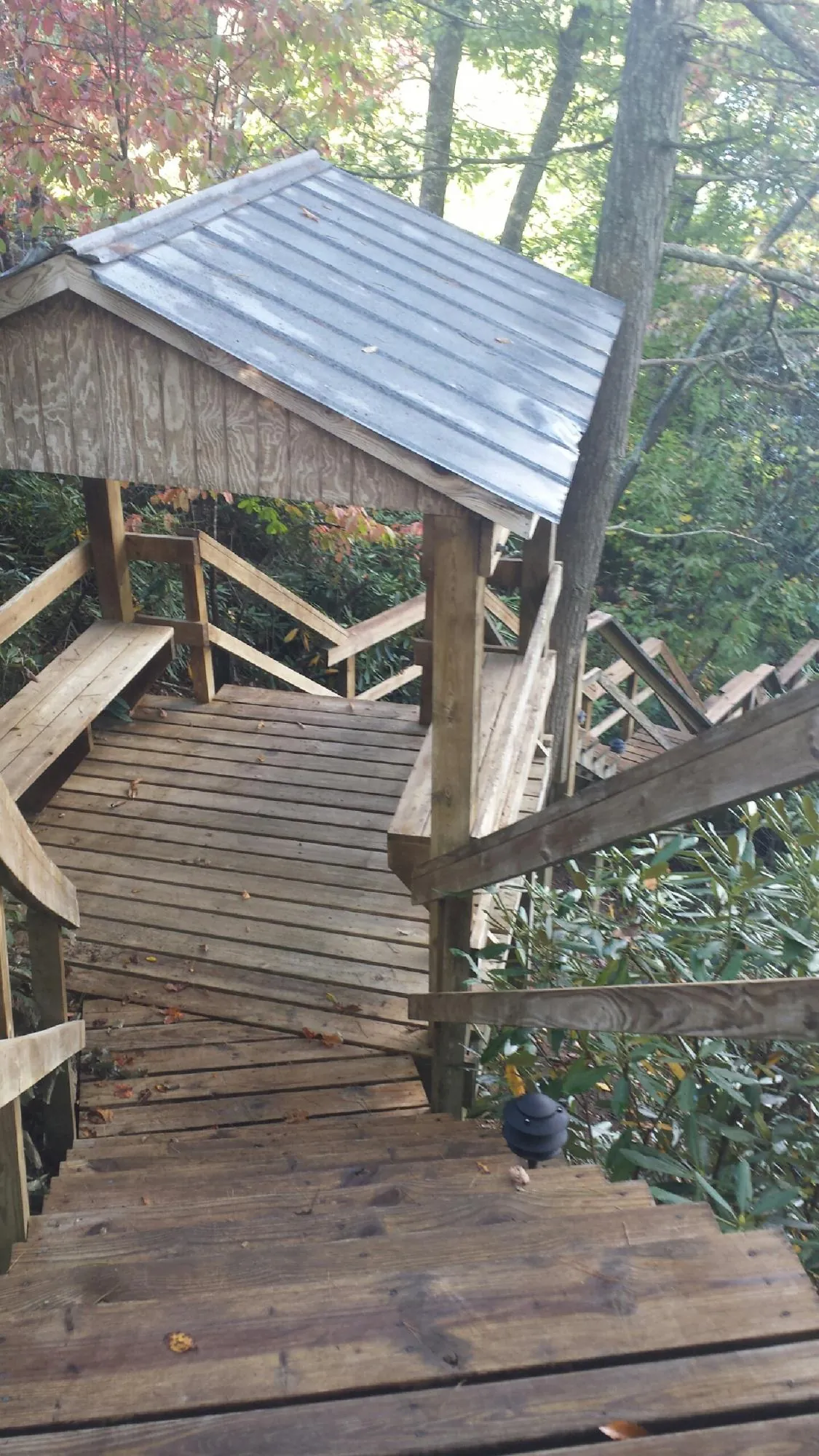 Metal roofed shelter over wooden steps on a wooded walkway — Skylight Repair & Installation work by our crew in Sperry